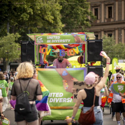 Tanzende Menschen und DJ Anhänger der Grünen Andersrum mit Motto "united in diversity"